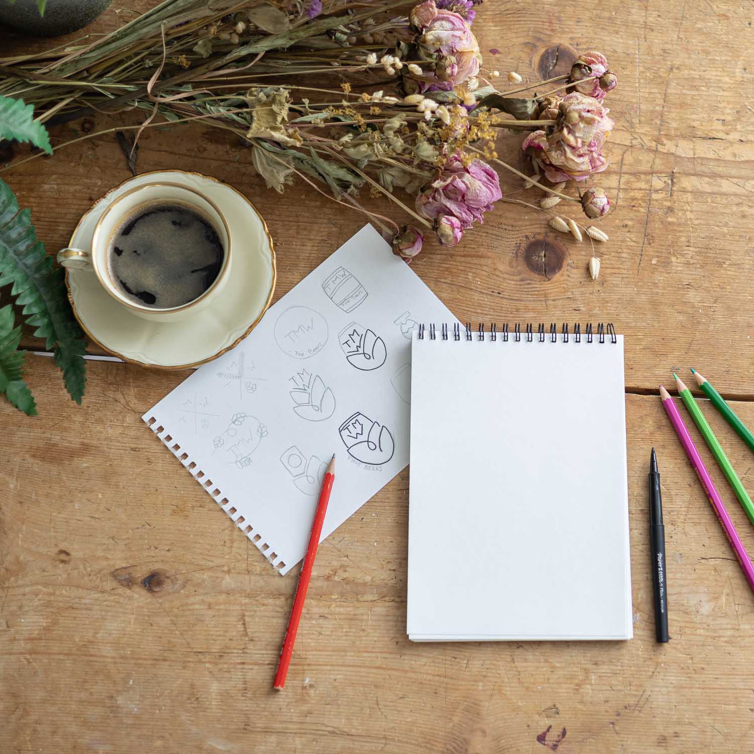 Skizzenblock und Stifte auf Holztisch