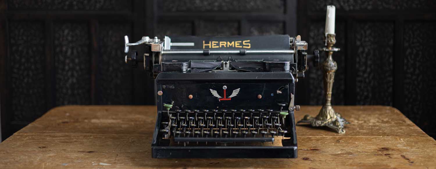 alte Hermes-Schreibmaschine auf Holztisch