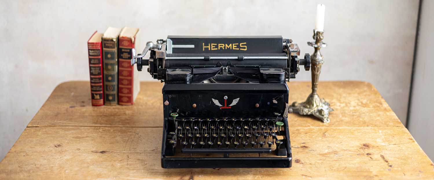 alte Hermes-Schreibmaschine auf Holztisch